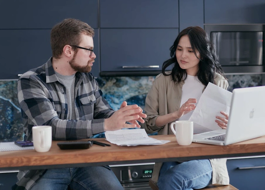 Osoba používající kalkulačku a procházející finanční dokumenty